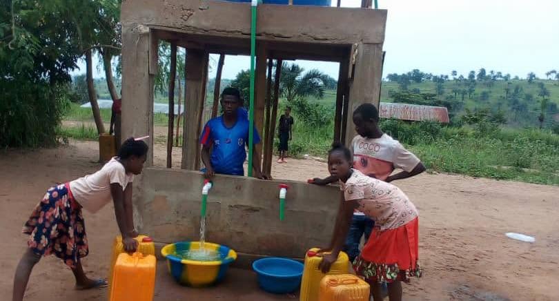 Kiosque du point d'eau terminé, enfants remplissant leurs bidons